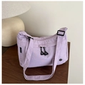 Detail of lilac nylon crossbody bag showing crinkled texture and zippered front pocket - Purple