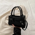 Classic black handbag with bow decoration and silver buckle in professional setting - Black