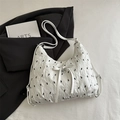 Chic pleated tote bag in off-white with black bow pattern and adjustable shoulder strap - White
