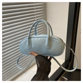 Detalle de bolso baguette azul claro en cuero sintético con asas y acabado mate suave - Azul