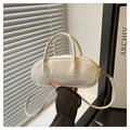 Detalle de un bolso bowling blanco minimalista de piel suave con herrajes plateados - Blanco