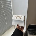 Borsa a sella bianca minimalista con chiusura a fiocco dorato e tracolla a catena - Bianco