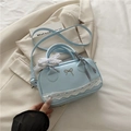 Light blue ballet-style Boston bag with white lace trim and metallic bow detail - Blue