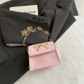 Mini borsa a sella rosa con fiocco dorato e tracolla a catena su blazer nero elegante - Rosa