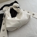 White bow-shaped underarm bag featuring silver rivet studs and matte leather finish - White