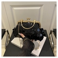 Detailaufnahme der schwarzen Pailletten-Abendtasche mit goldenem Metallgriff und Kette - Schwarz