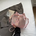 Rosafarbene gesteppte Beuteltasche mit bunten Nähten und Kordelzug auf dem Bett - Rosa