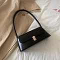 Bolso de hombro tipo baguette negro con hebilla dorada sobre una gabardina beige - Negro