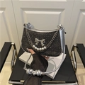 Chic black sequin underarm bag with silver bow and pearl strap shown in hand - Black