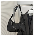 Detail van glanzende zwarte hobo tas met verstelbare zilveren gesp aan een hanger - Zwart
