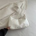 White crescent underarm bag in glossy synthetic leather with minimalist modern silhouette - White