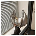 Nahaufnahme der silbernen Halbmondtasche mit Metallic-Finish und Perlen-Schleifen-Anhänger - Silber