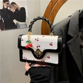 Bolso bandolera con estampado de cerezas, asa trenzada negra y cierre de trébol metálico - Negro
