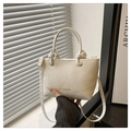 Dettaglio borsa a mano crema effetto pitonato con scritta FASHION e manici a nodo - Bianco