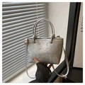 Detail der silbernen Handtasche mit Schlangenmuster, Fashion-Logo und Knotengriffen - Silber