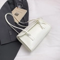 French style white ribbon baguette bag with bow detail on a minimal studio background - White