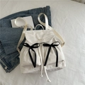 White nylon drawstring backpack with black bows and Nika embroidery detail - White