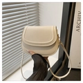 Detail der minimalistischen cremefarbenen Satteltasche mit feinen Nähten und Klappe - Weiß