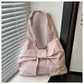 Dettaglio del grande fiocco rosa su una borsa a tracolla in tela capiente per donna - Rosa