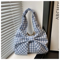 Detail of blue and white gingham handbag with a large decorative bow and soft shadows - Blue