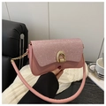 Detailed shot of pink glitter shoulder bag featuring an arched gold metal clasp and chain - Pink