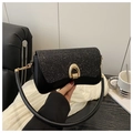 Detail of black glitter shoulder bag featuring a gold horseshoe twist lock and leather strap - Black