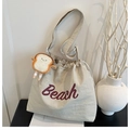 Canvas drawstring tote bag with red Beach lettering and cute toast plush pendant detail - White With Pendant