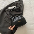 Minimalist black pleated bucket bag with leather texture and thin adjustable shoulder strap - No Pendant / Black