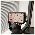 Detail of crossbody bag with cherry print, adjustable wide strap and gold hardware - Black With Pendant