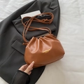Caramel pleated bucket bag with long strap displayed on a dark grey blazer - Brown Without Pendant