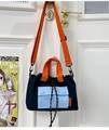 Detail of color-block nylon bucket bag with orange straps and drawstring closure - Dark Blue