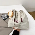 Beige oversized drawstring tote bag with red Peach lettering and bread plush charm - White With Pendant