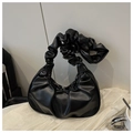 Primer plano detallado de un bolso de nube plisado negro en cuero sintético suave y liso - Negro