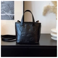 Detail of black embossed tote bag featuring butterfly patterns and gold hardware accents - Basic Style / Black