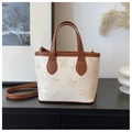 Detail of embossed floral and butterfly patterns on white and brown tote bucket bag - Basic Style / Off White
