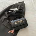 Black quilted crossbody bag with gold rhinestone LOVE logo and wide textile strap - Black