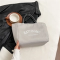 Light gray large tote bag with letter print and textured woven handles on a desk - Gray