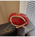 Close-up of red oval leather bag with gold metal ring handle and fine chain strap - Red