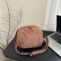 Bolso bandolera minimalista de pana marrón con doble cremallera sobre un escritorio moderno - Marrón