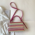 Detail van kleurrijke geweven boho handtas met roze leren handvat en gouden beslag - Rozerood