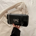Minimalist black leather crossbody bag with a silver metal bow buckle and chain strap - Black