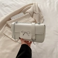 Elegant white chain crossbody bag with silver bow accent and minimalist leather texture - White