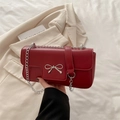 Chic deep red leather shoulder bag with silver bow accent and elegant chain strap - Red