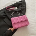 Pink quilted crossbody bag with silver chain strap on a black blazer jacket - Pink