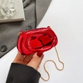 Metallic red mirror finish clutch bag with gold chain strap shown in an urban setting - Red