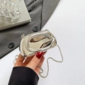 Irregular silver chrome clutch bag with metal chain shown in a stylish lifestyle setting - Silver