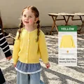 Geel gebreid vest voor meisjes met klassiek kabelpatroon en witte knopen in het park - 100cm / Geel