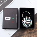 Macro shot of a mini football keychain with Brazuca pattern inside a black FIFA gift box - Style E Soccer Ball Keychain With Gift Box