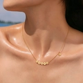 Detailed view of gold daisy necklace featuring seven flower pendants on a female neck - 5+1 Daisy Flowers
