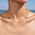 Detail of daisy flower pendants on a gold chain necklace worn against a water background - Box Chain + 5 Daisy Pendants